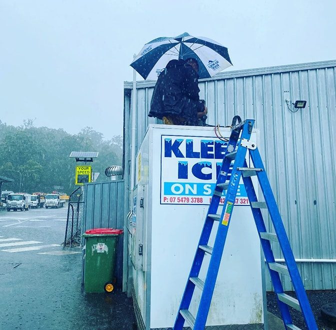 Technician Repairing Ice Box While Raining — Instachill in Gold Coast, QLD