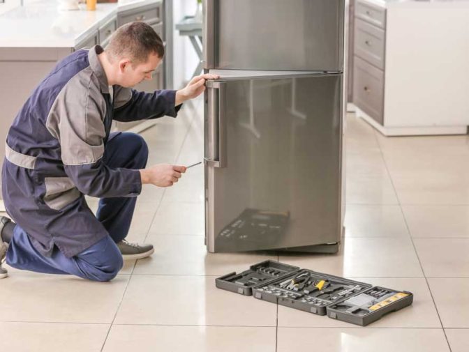 Technician Repairing Refrigerator In The Kitchen — Instachill in Gold Coast, QLD